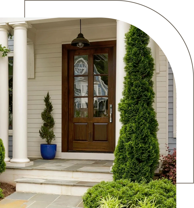 A front door of a house with bushes and trees.