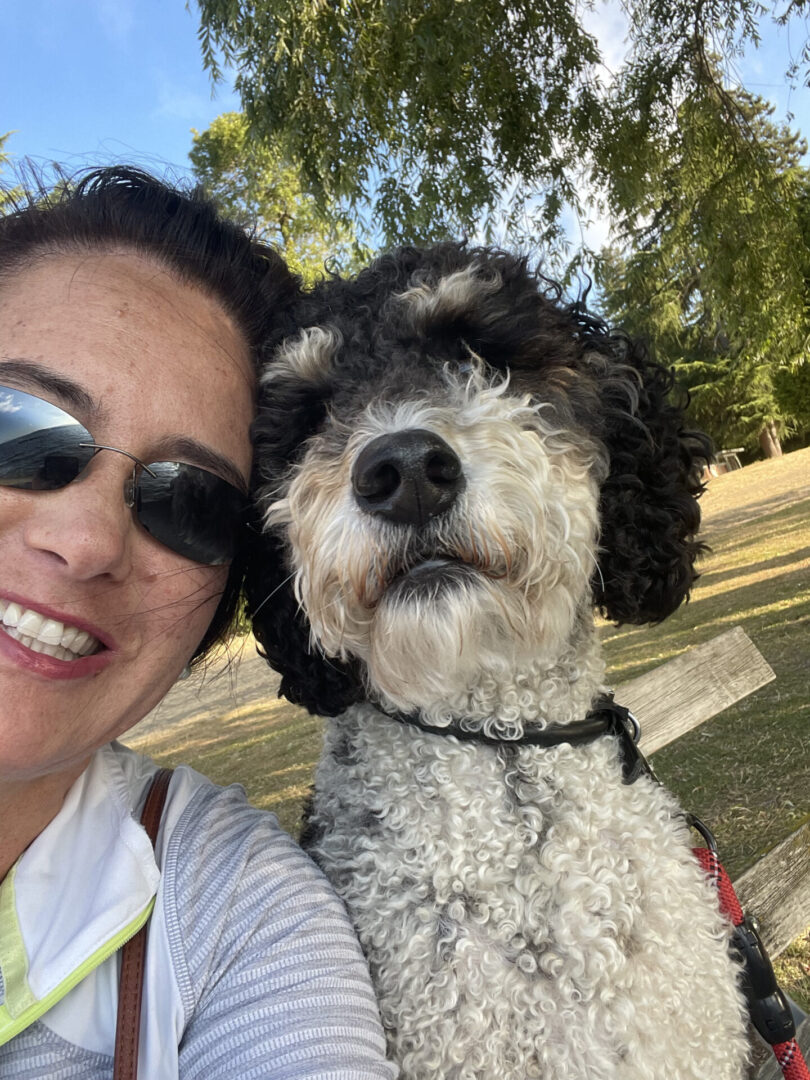 A woman and her dog are smiling for the camera.